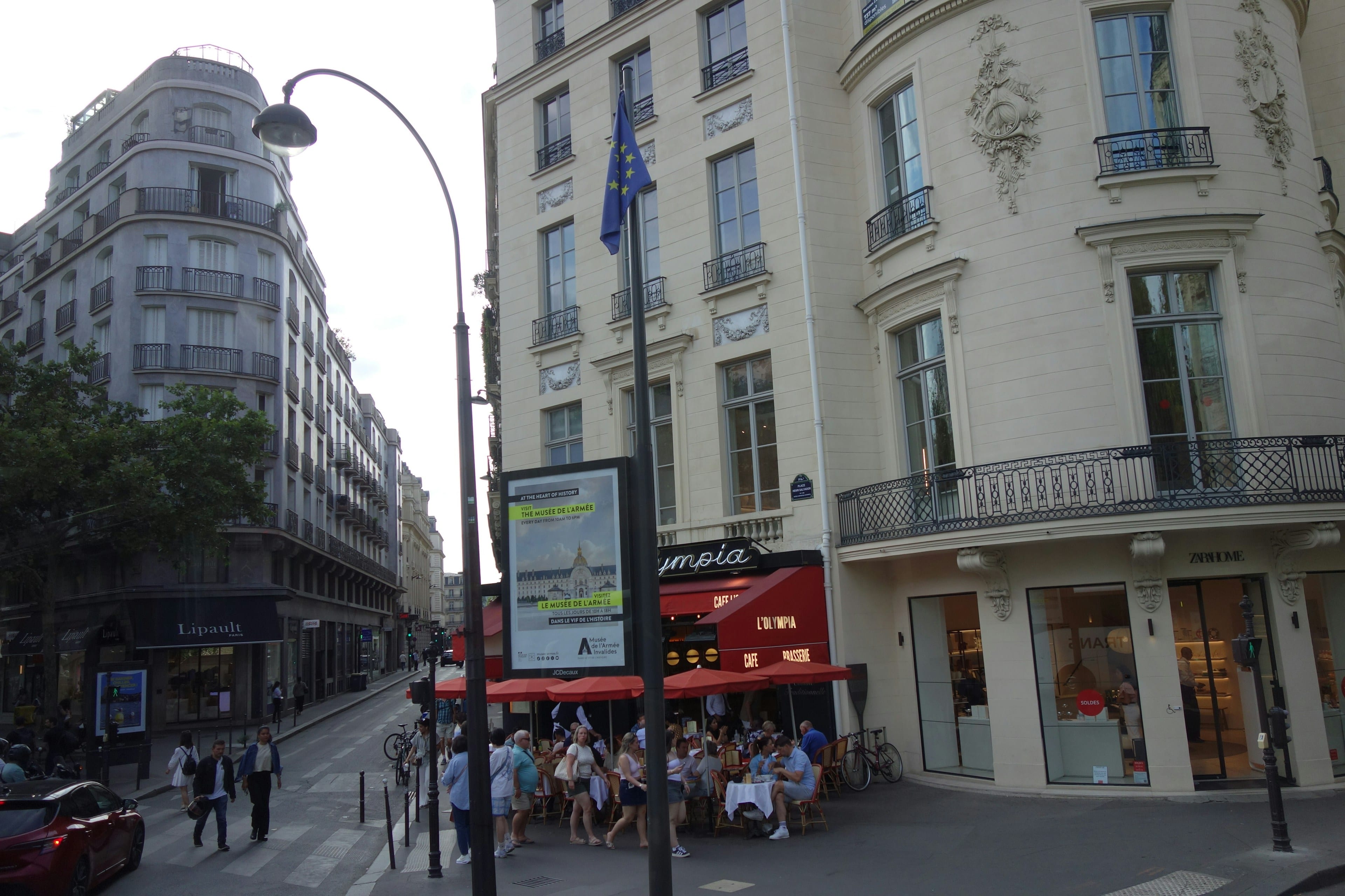 Rue commerçante parisienne bordée d’immeubles haussmanniens